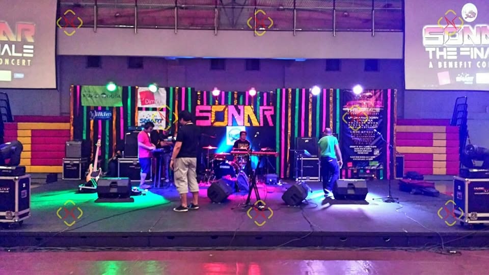 Live band stage equipped with Soundph speakers, monitors, instruments and colored lighting